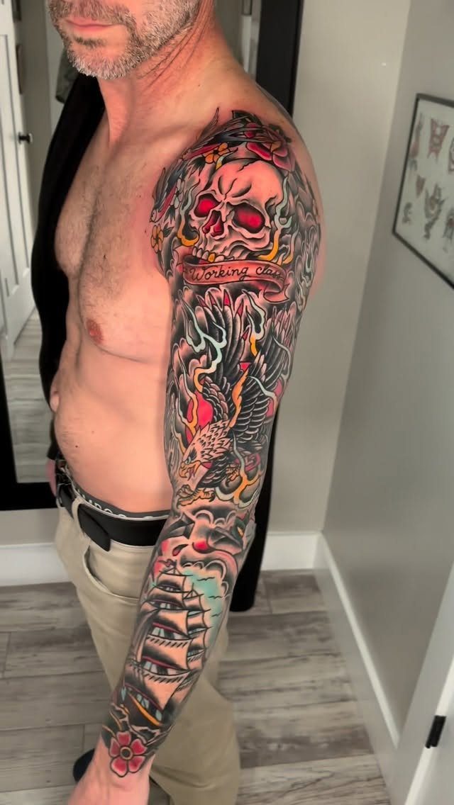 Full sleeve American traditional tattoo on a man's arm featuring a skull and ship.