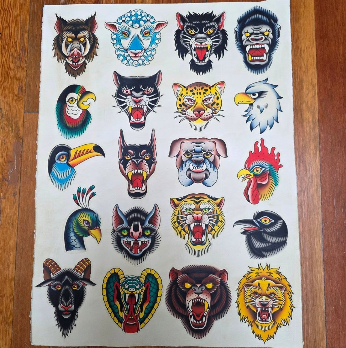 Tattoo flash sheet with various bold animal head designs on white paper.