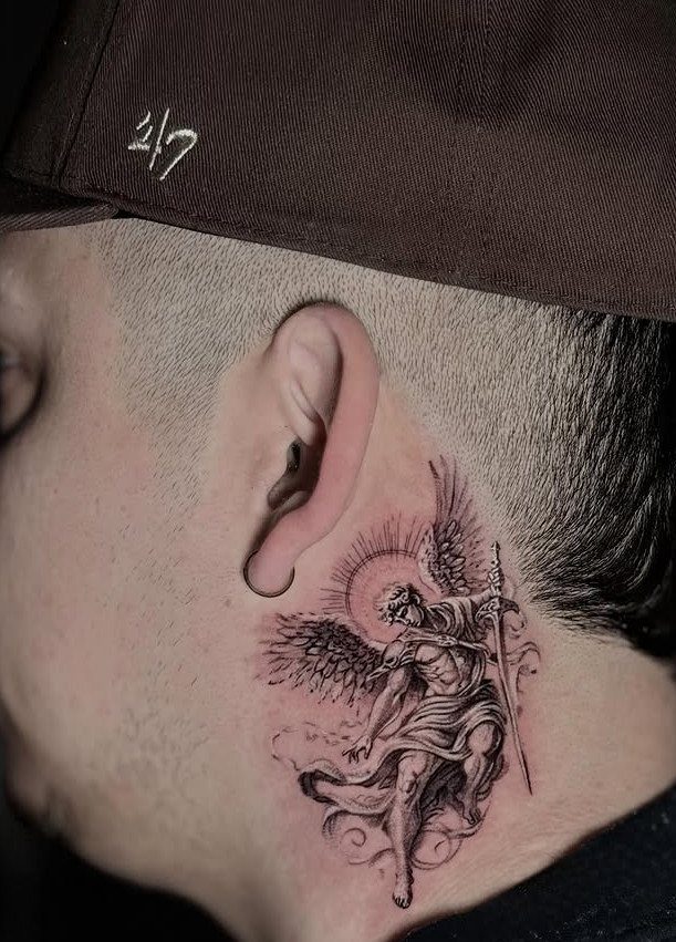 Detailed angel tattoo with a sword on a man's neck behind the ear