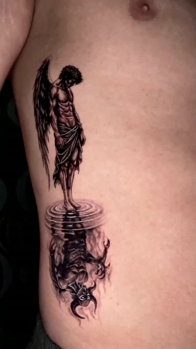 Angel tattoo on a torso with a demonic devil reflection in water