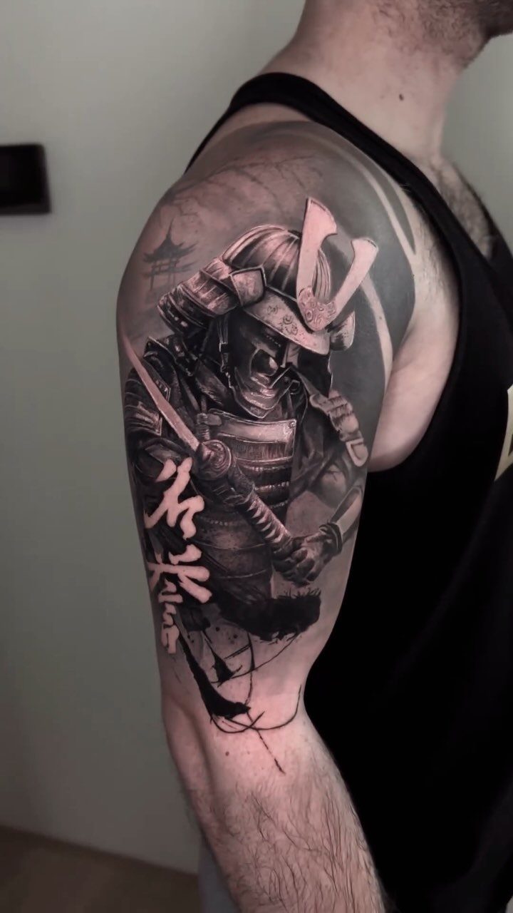 Samurai warrior tattoo in black and grey ink on a man's upper arm