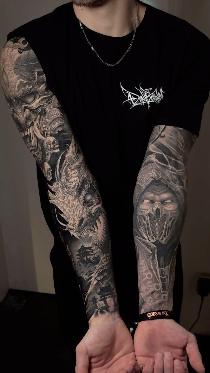 Full sleeve tattoos on arms featuring a Japanese dragon and a masked figure.