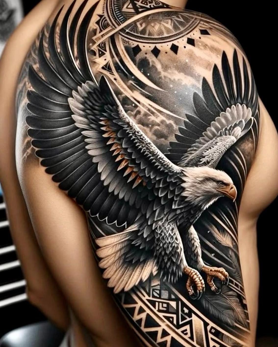 Bald eagle tattoo with Aztec geometric patterns on a person's shoulder and arm.