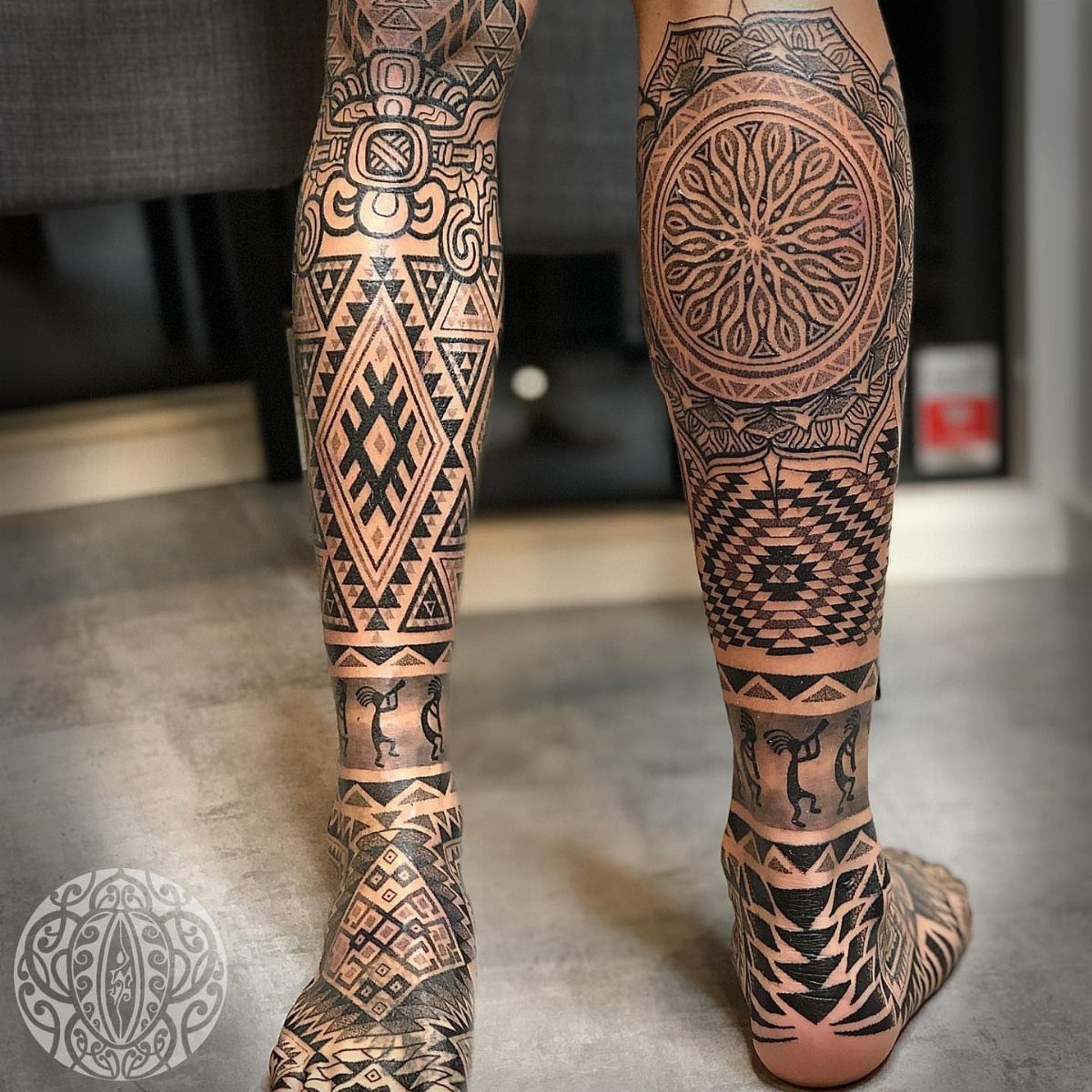Lower legs and feet featuring detailed black ink Aztec pattern tattoos.