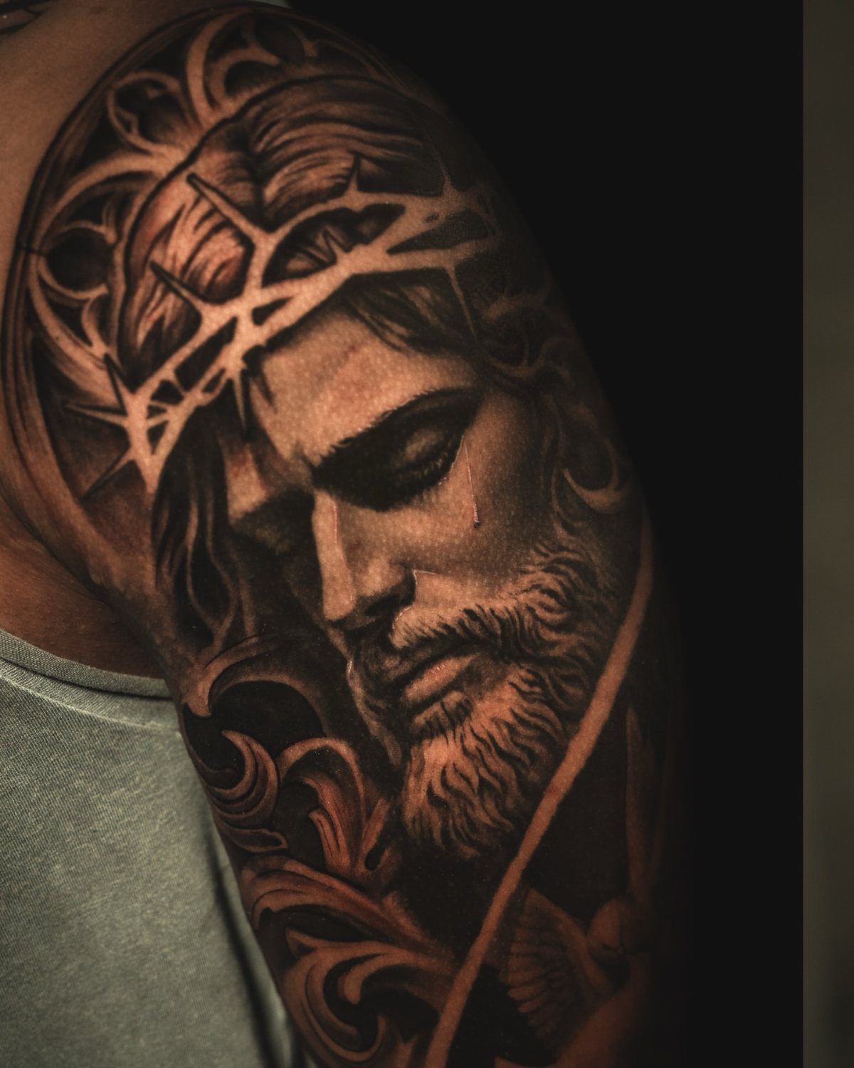 Detailed black and grey realism tattoo of Jesus with crown of thorns on arm