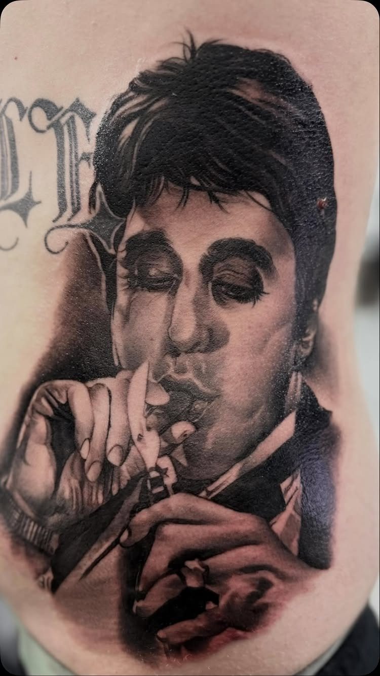 Realism black and grey tattoo of a man smoking a cigarette on skin.