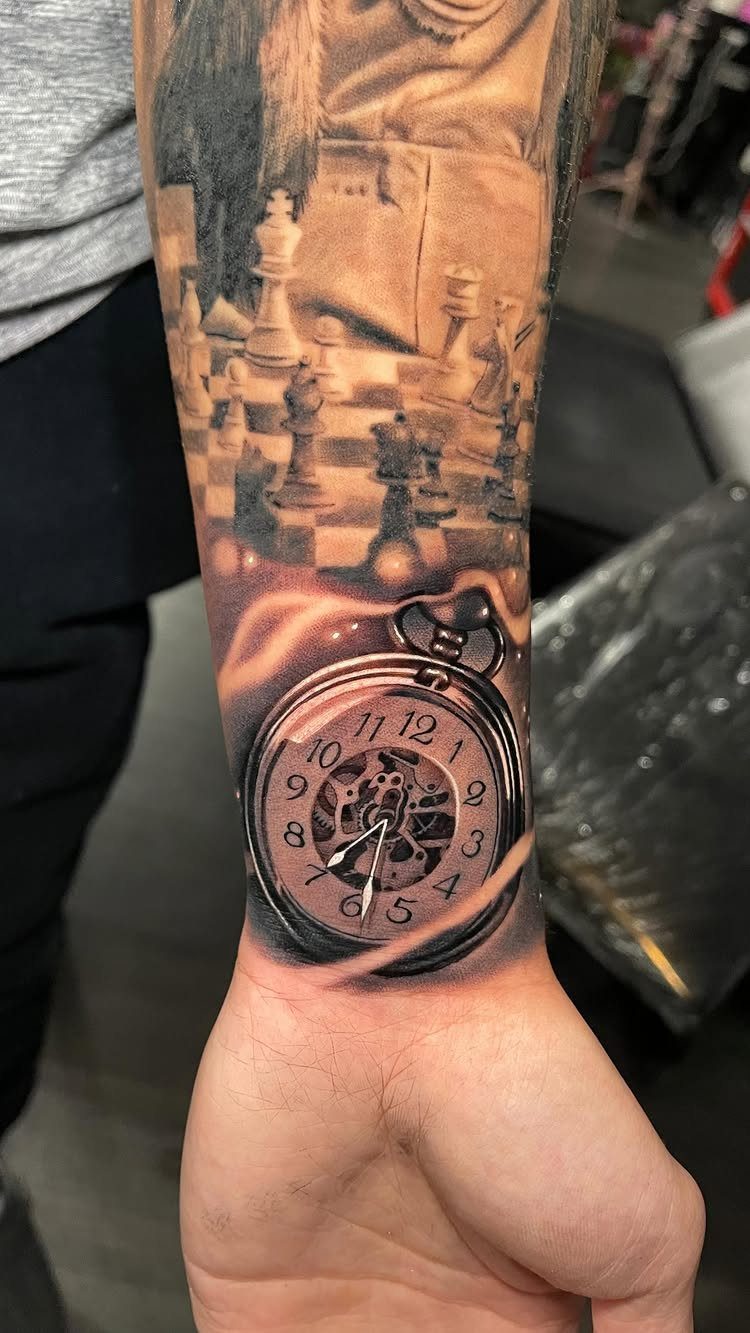Pocket watch and chessboard black and grey tattoo on a person's forearm