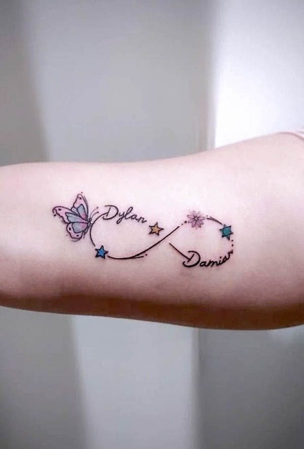 Tattoo on forearm with purple butterfly, infinity symbol, names, and small stars.