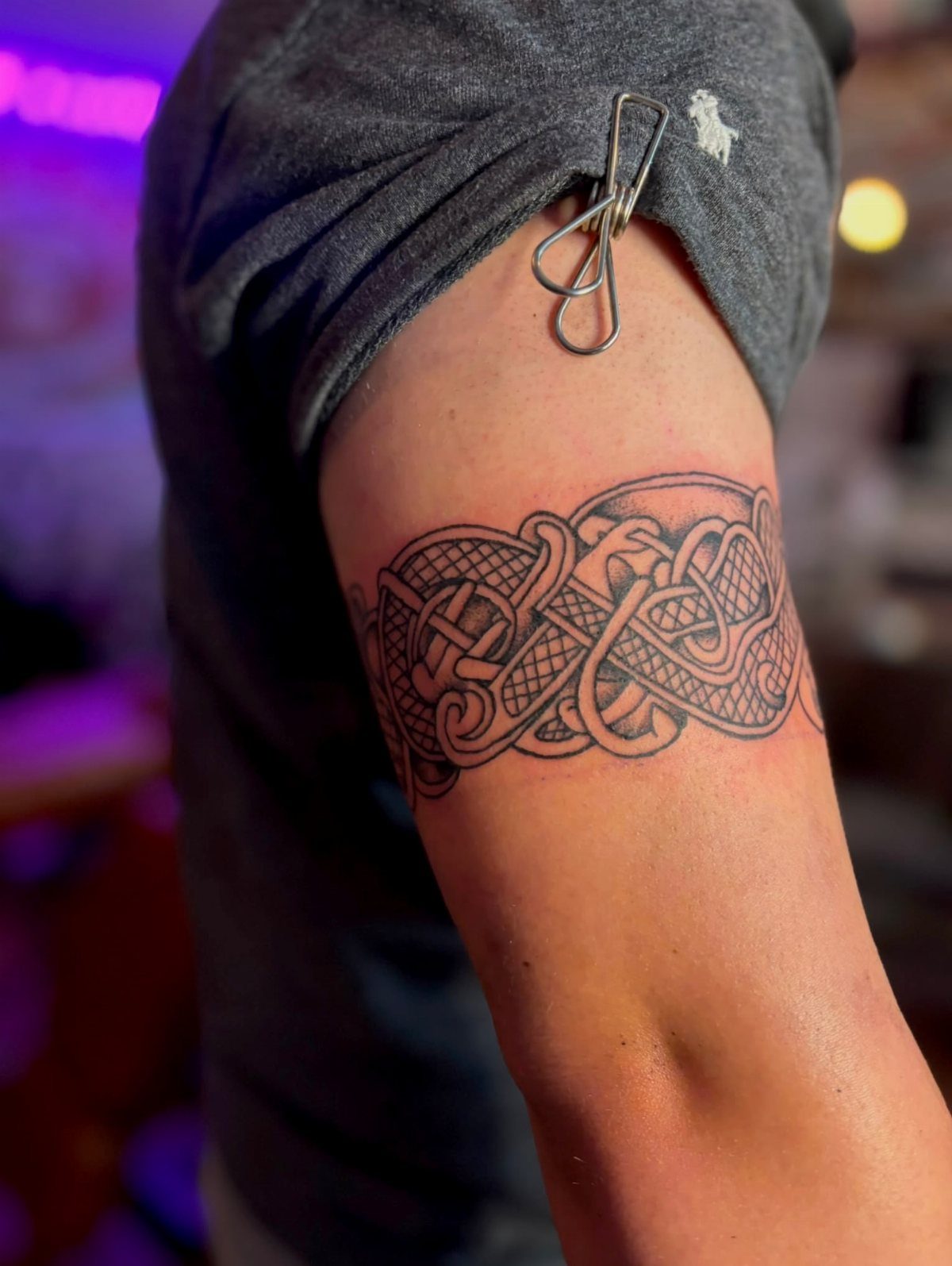 Celtic knot tattoo band wrapped around a person's upper arm in black ink