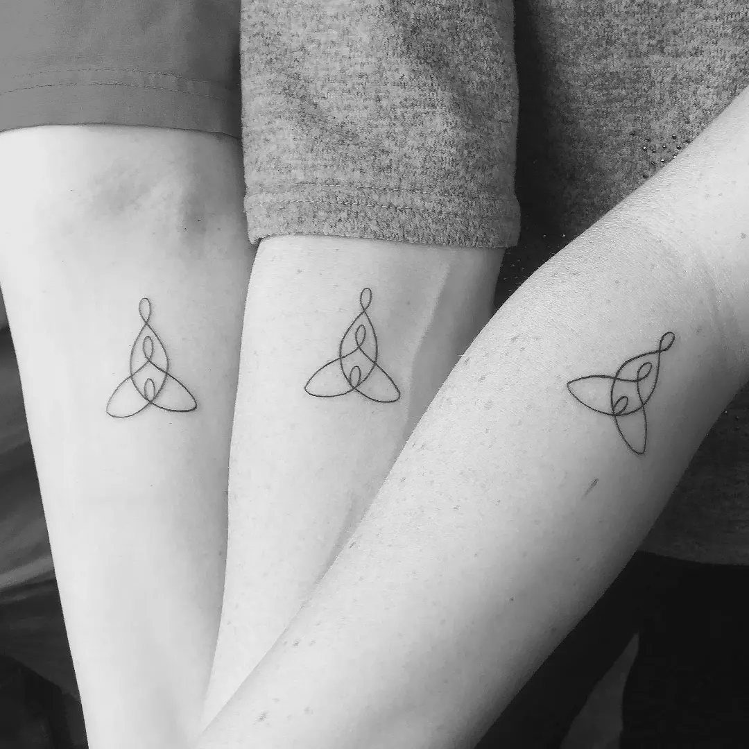 Three forearms with matching black ink trinity knot tattoos on the inner wrists.