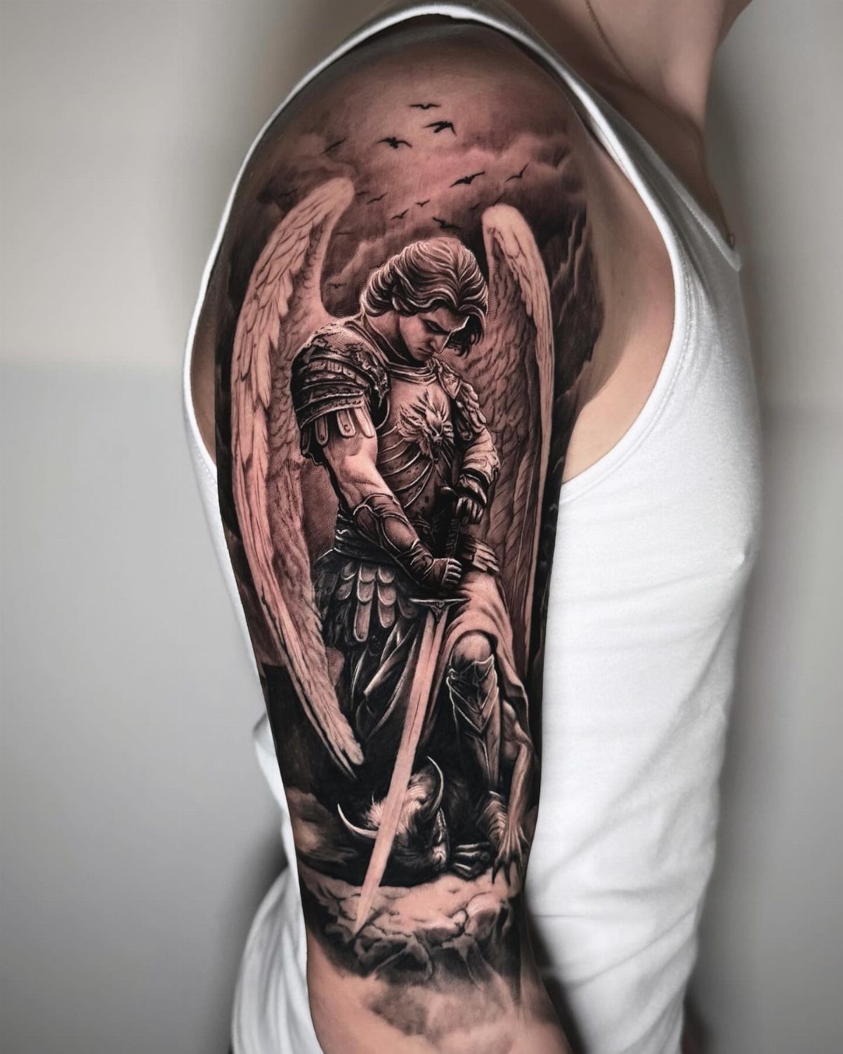 Winged angel in armor tattoo on a person's upper arm sleeve