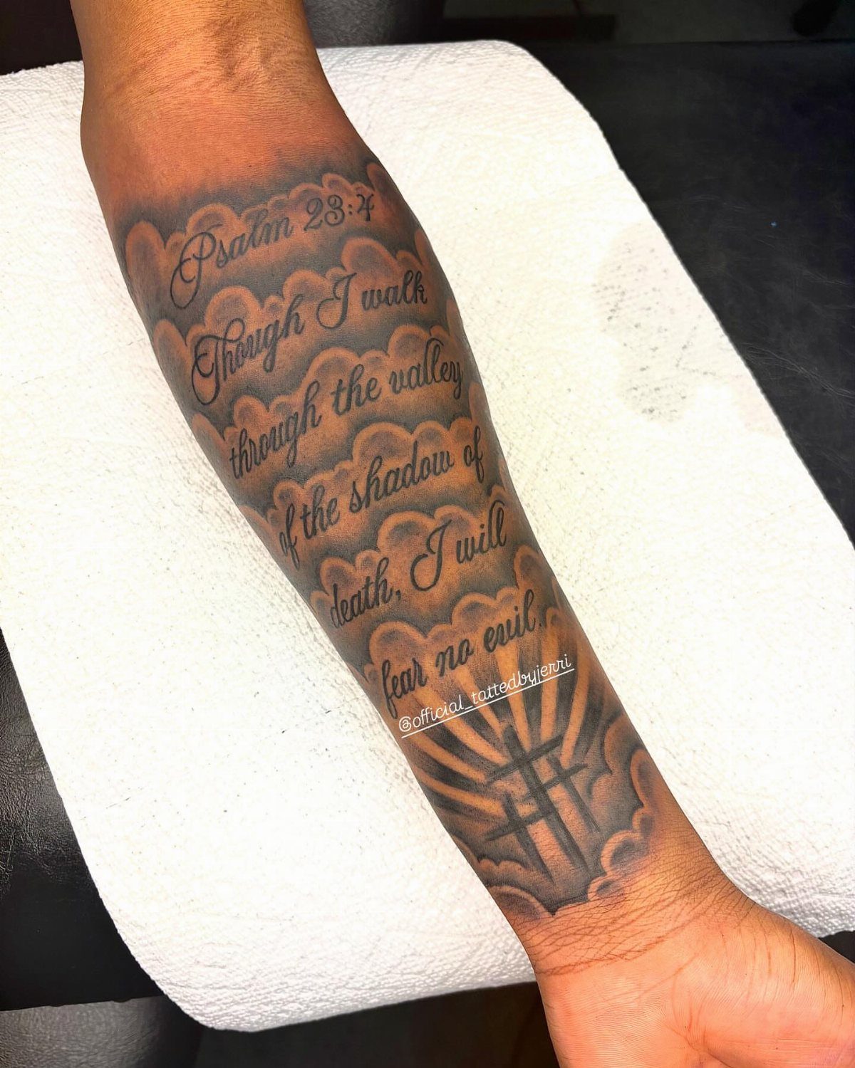 Forearm tattoo featuring Psalm 23:4 scriptural quote with clouds and a cross.