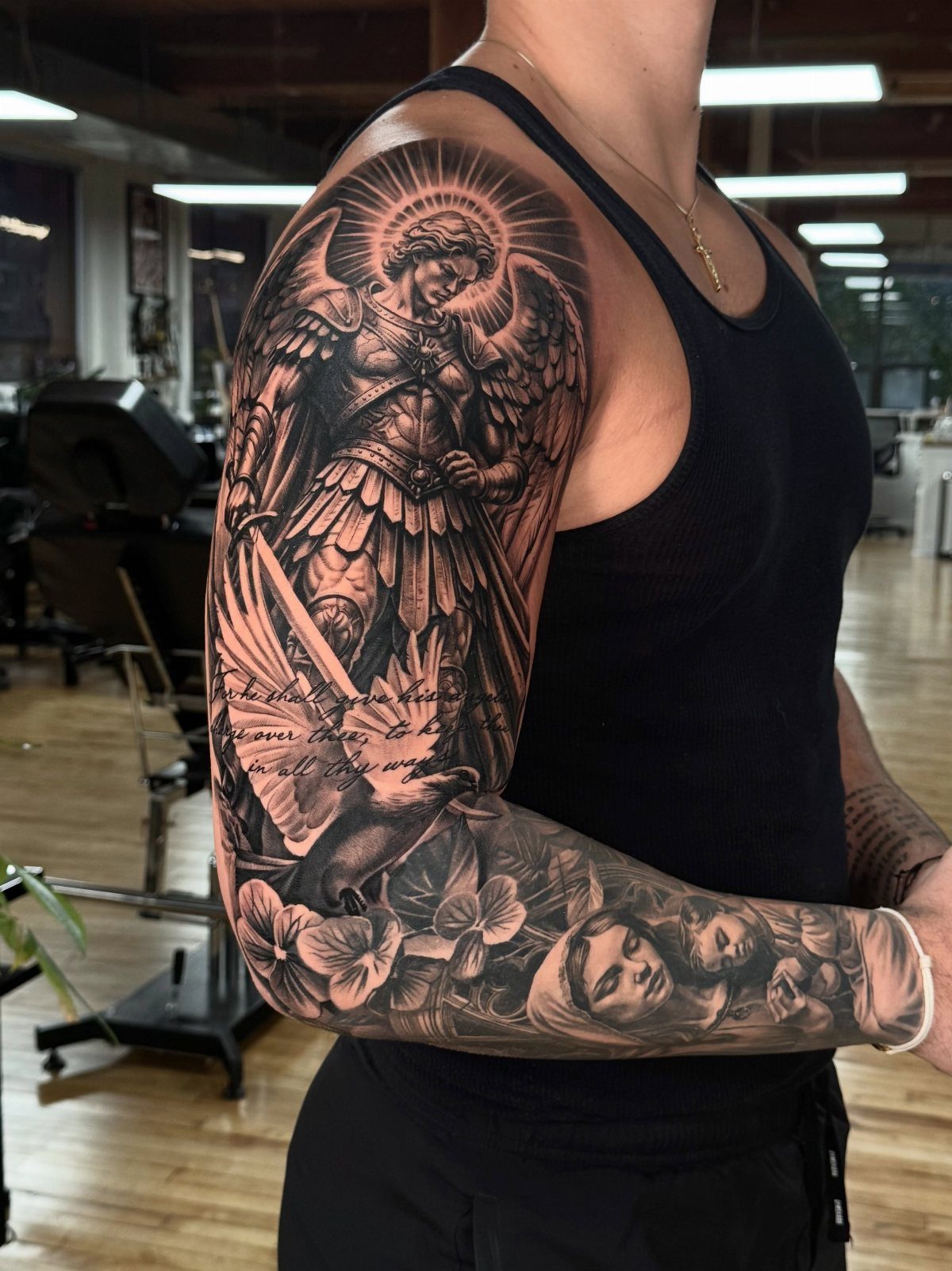 Armored angel warrior sleeve tattoo with a sword, dove, and floral elements.