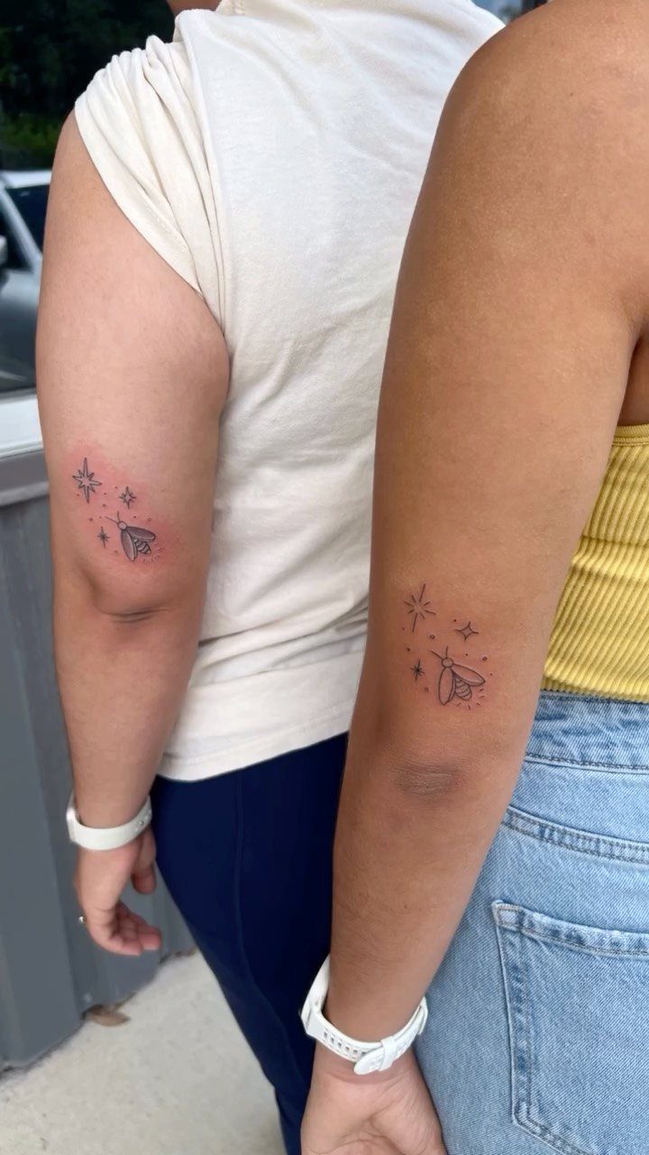 Matching bee and star tattoos on the upper arms of two people.