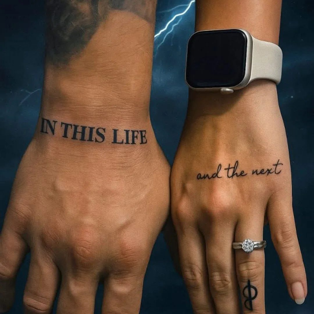 Two hands with matching tattoos that read 'IN THIS LIFE and the next'