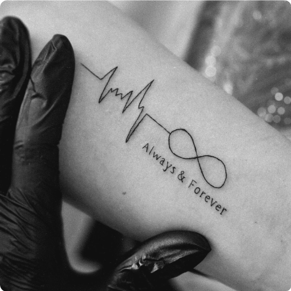 Heartbeat line tattoo transitioning into an infinity symbol with Always & Forever text.
