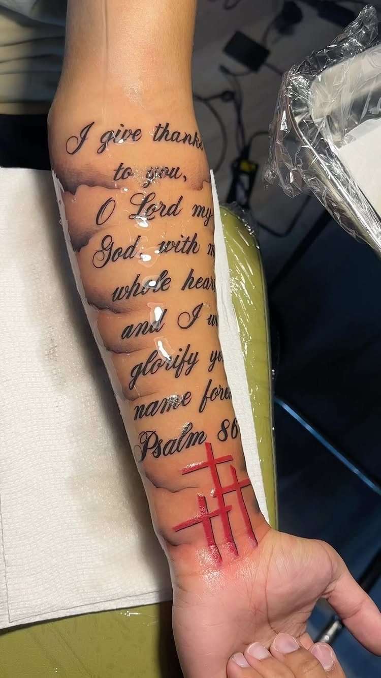 Tattoo on inner forearm with religious scripture and three red crosses on wrist