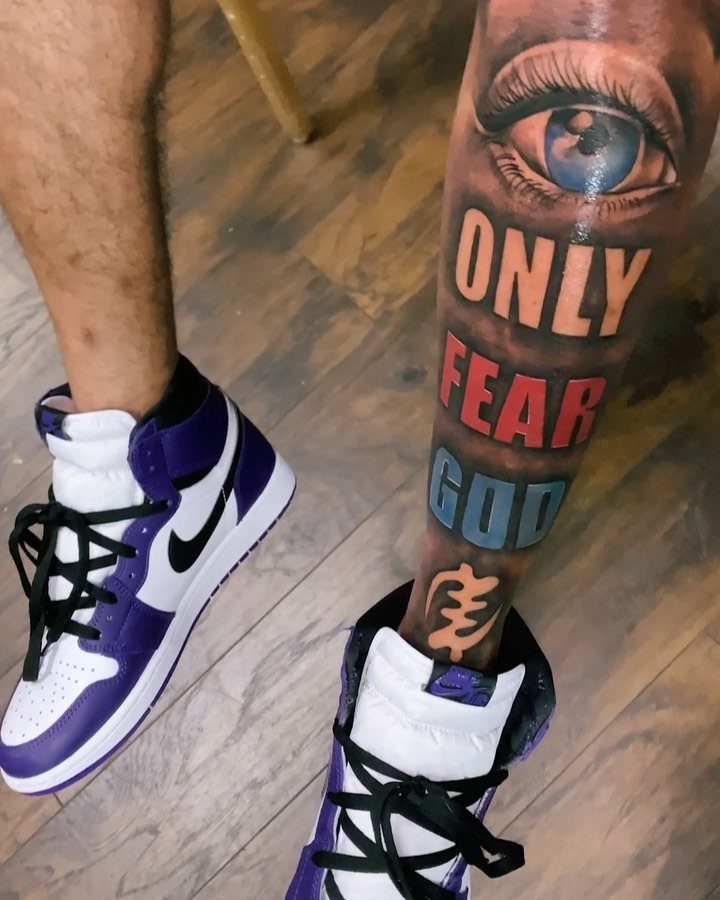 Leg tattoo with a large eye and the words Only Fear God