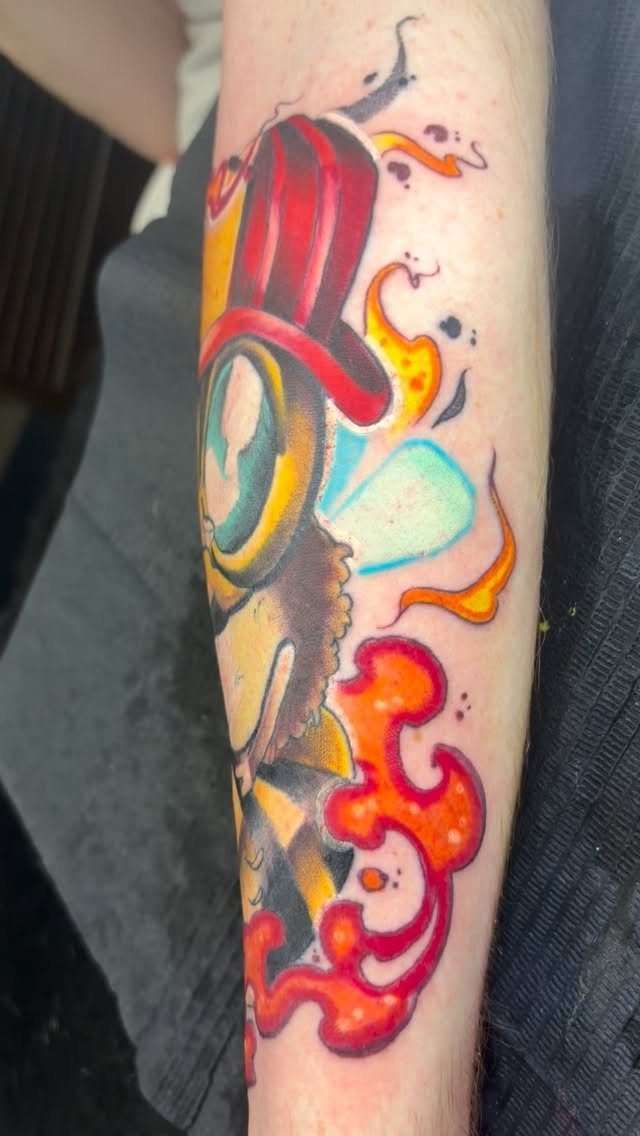 Colorful new school tattoo of a character with a red top hat on an arm