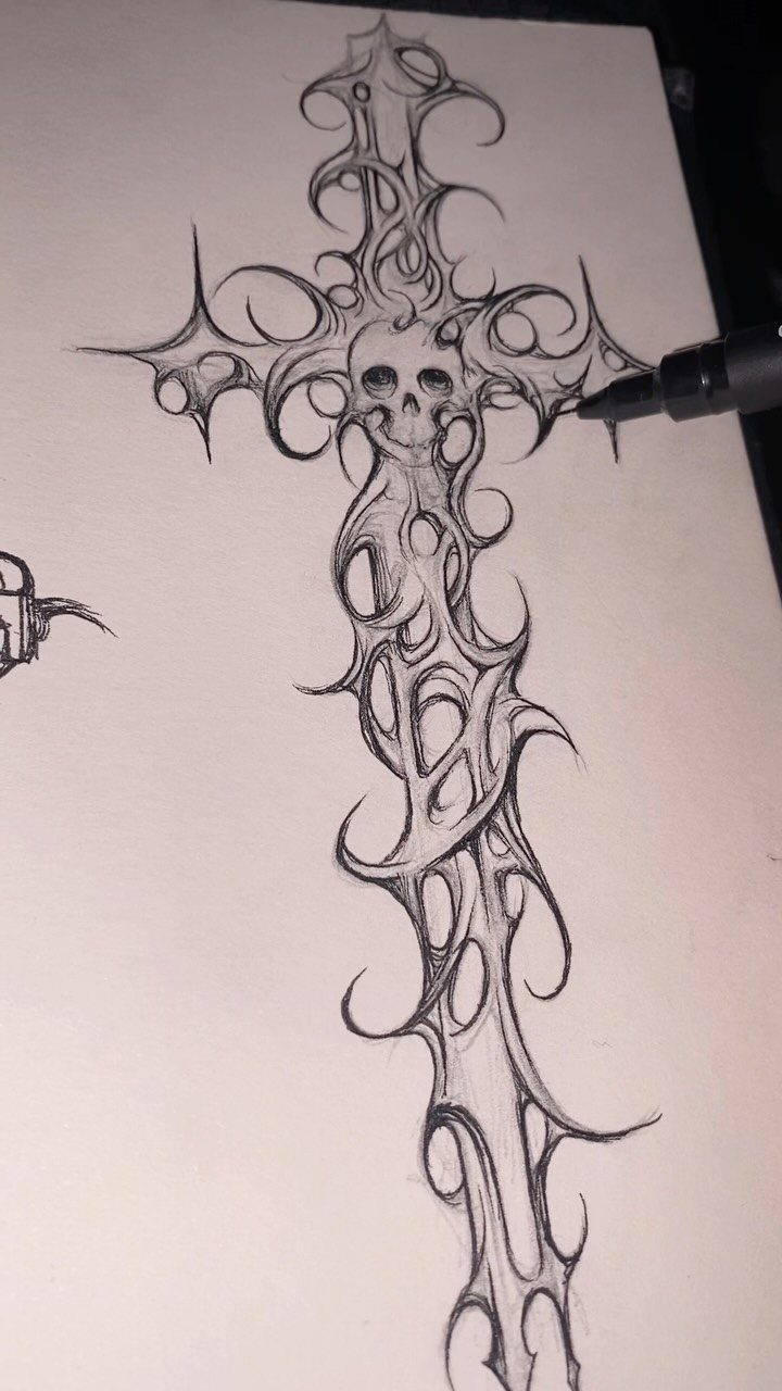 Gothic cross tattoo design with a skull and ornate filigree drawn in ink