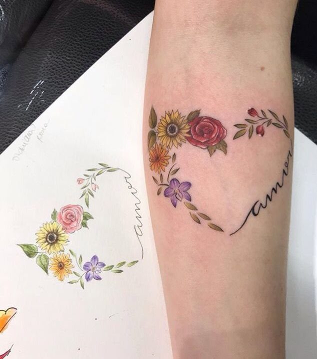 Floral heart tattoo with the word amor on a person's forearm