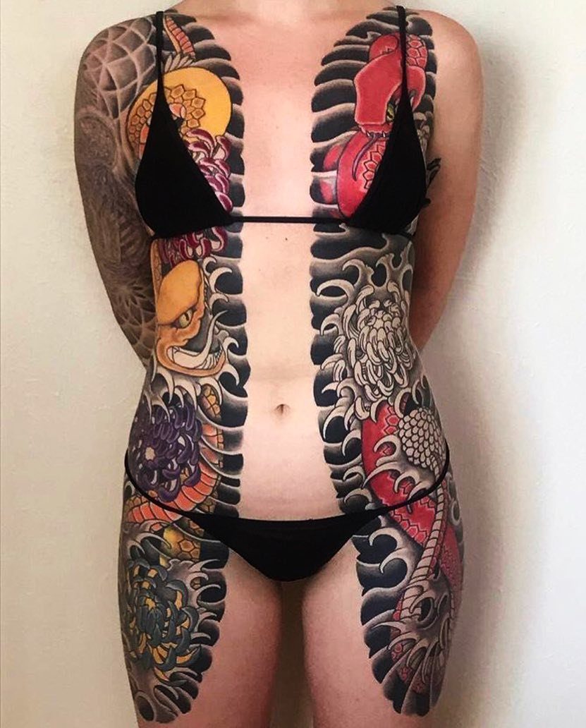 Person with extensive traditional Japanese bodysuit tattoos covering the torso and arms.