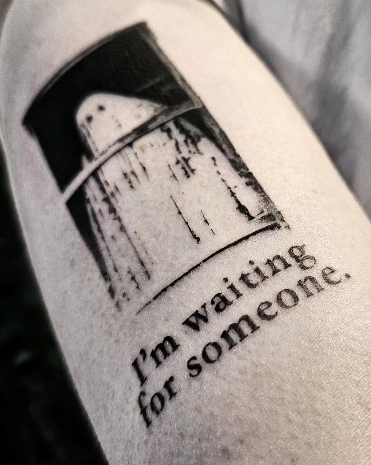 Typewriter font tattoo on an arm with the words I'm waiting for someone.