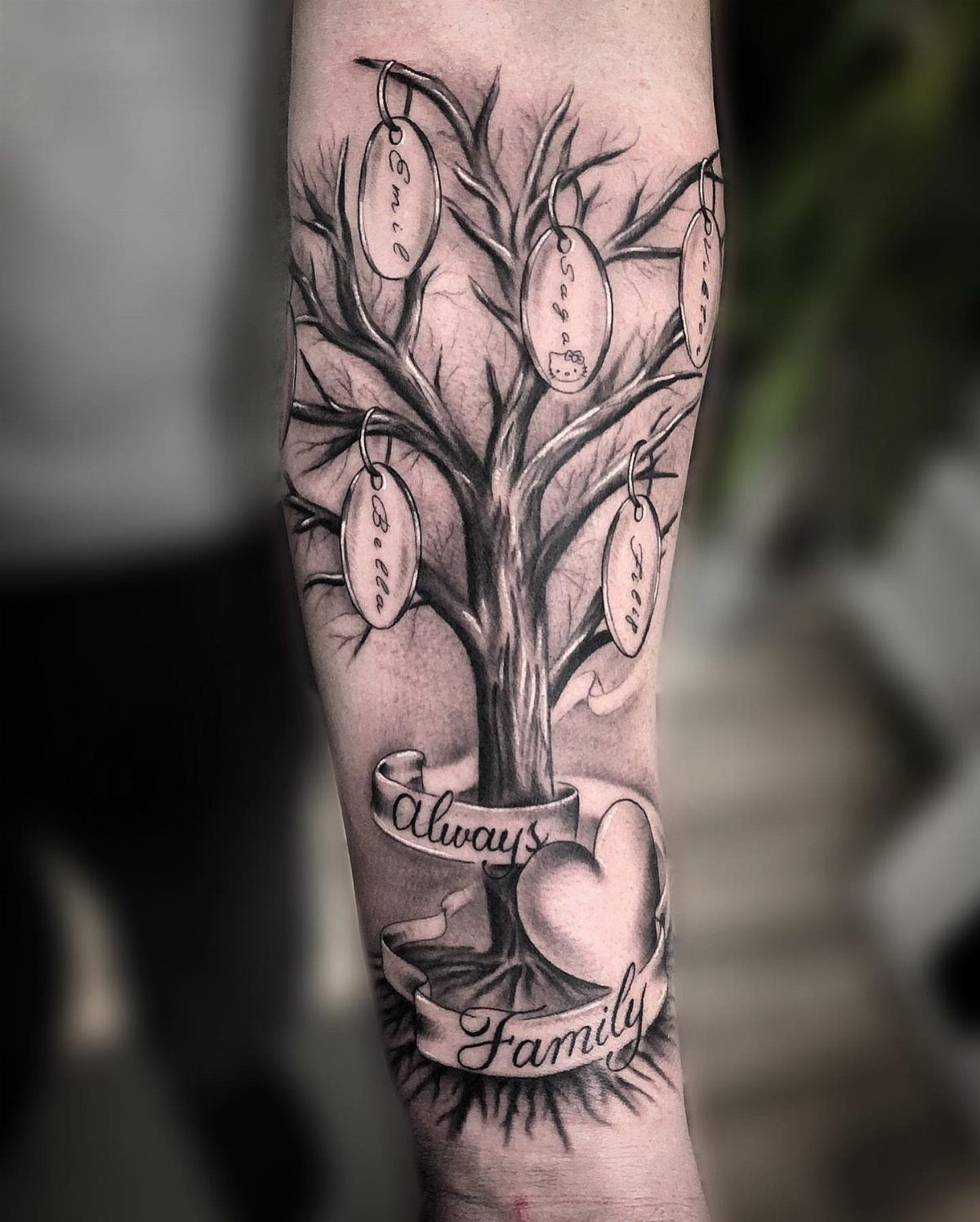 Family tree tattoo on a forearm with a heart and Always Family ribbon.