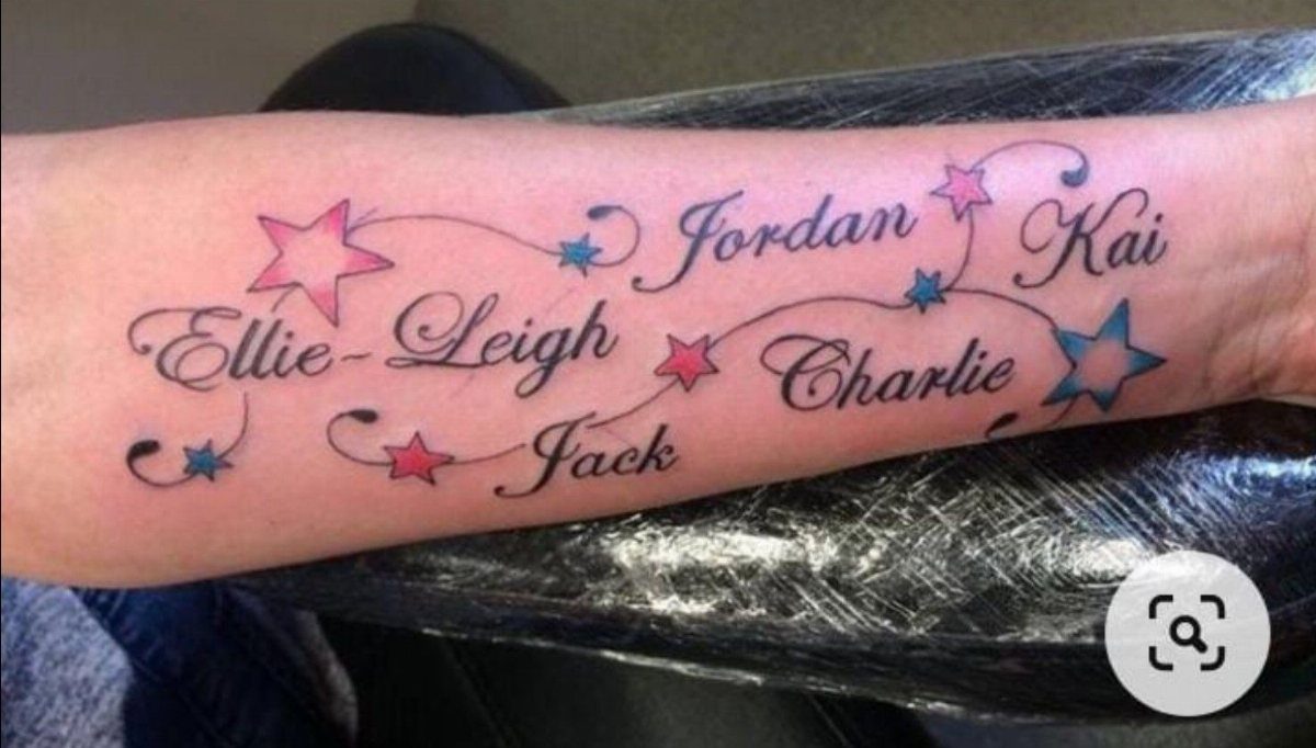 Cursive name tattoos on a hand decorated with small red and blue stars.