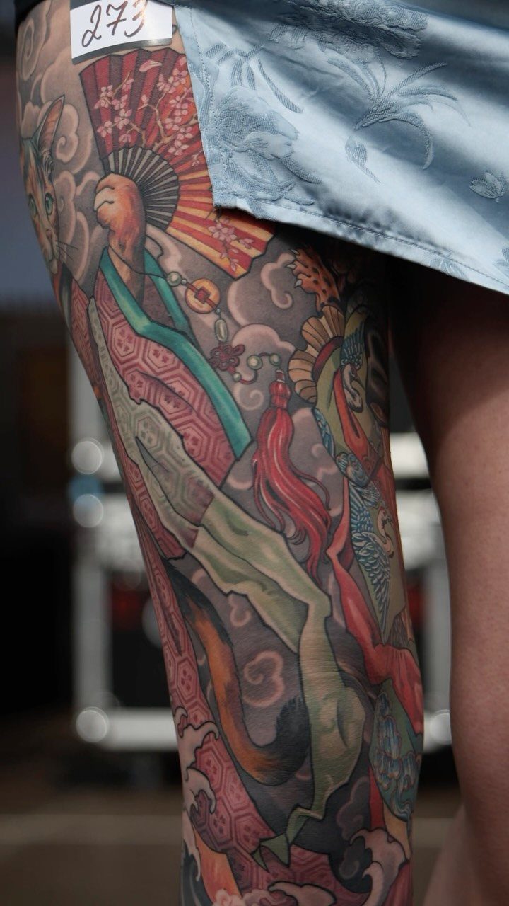 Colorful Japanese style tattoo on a leg featuring traditional figures and clouds