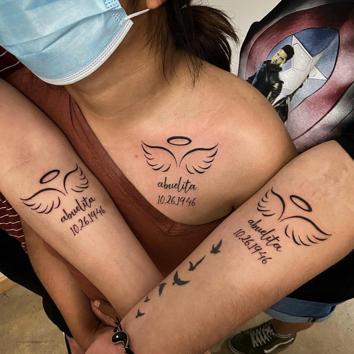 Memorial tattoos with angel wings, the word abuelita, and a specific date.