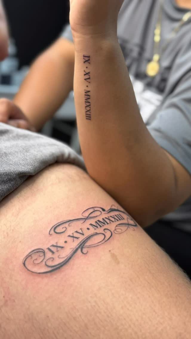 Matching Roman numeral date tattoos on a forearm and a person's torso.