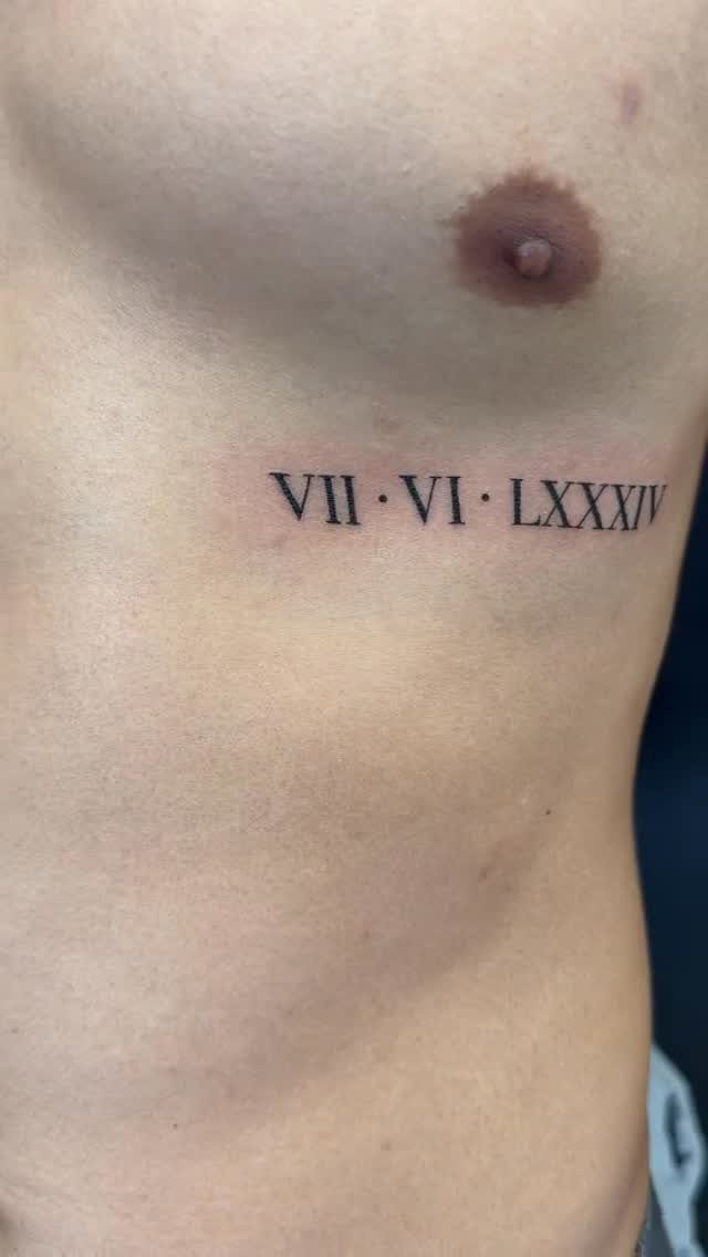 Roman numeral tattoo on a person's chest below the pectoral muscle
