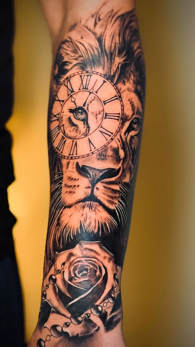 Lion tattoo on forearm with a Roman numeral clock and a rose.