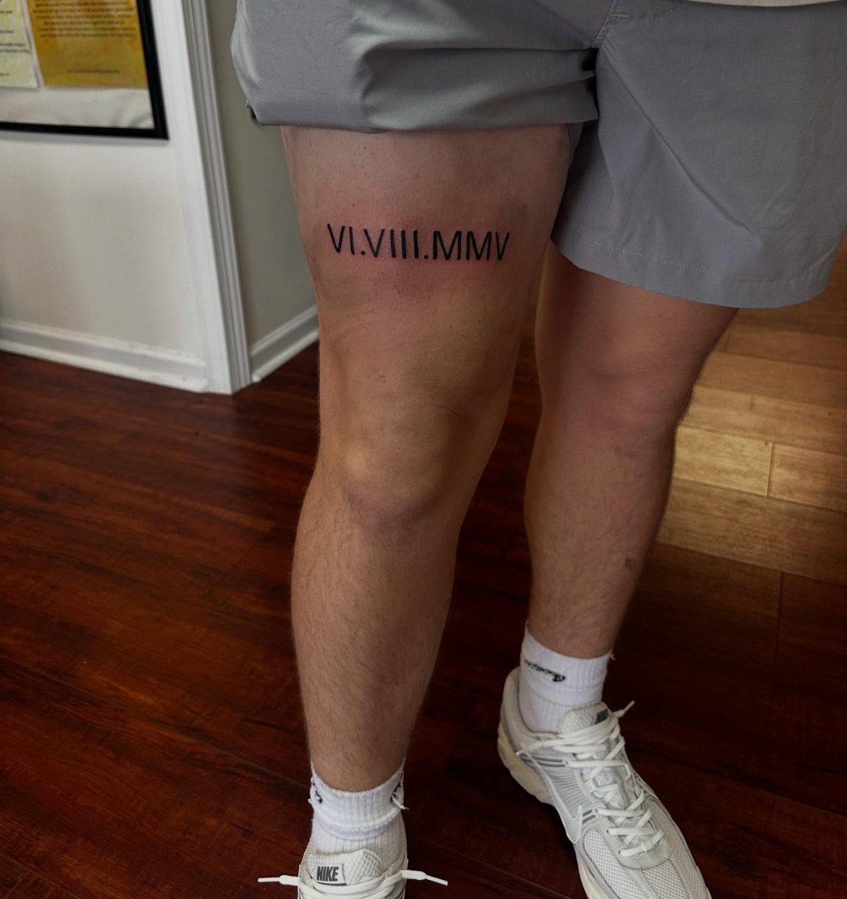 Roman numeral tattoo on a person's thigh featuring the date VI.VIII.MMV