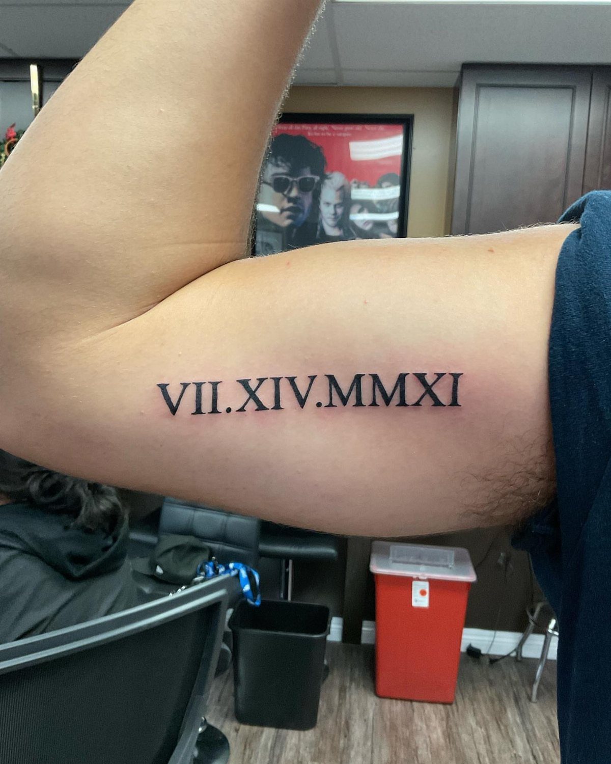 Roman numeral date tattoo on the inner arm of a person