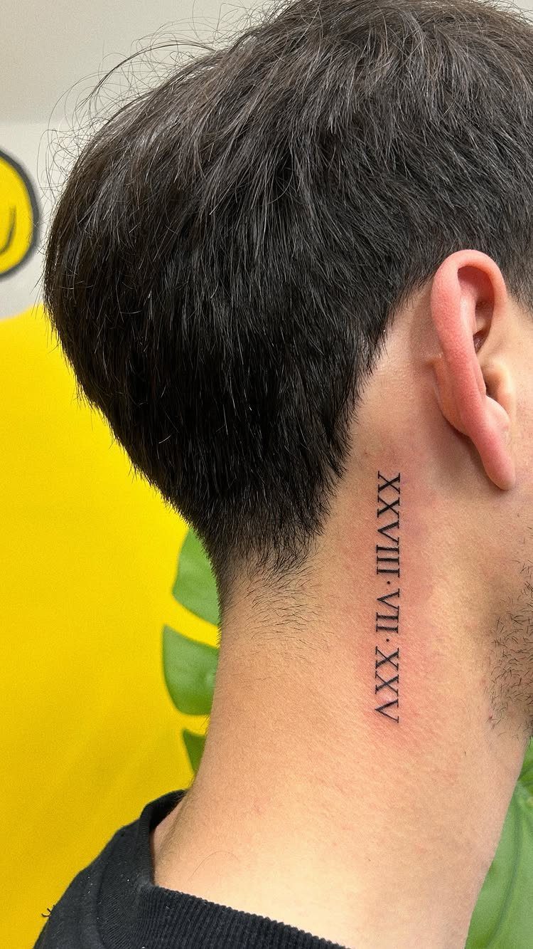 Vertical Roman numeral tattoo on the side of a person's neck