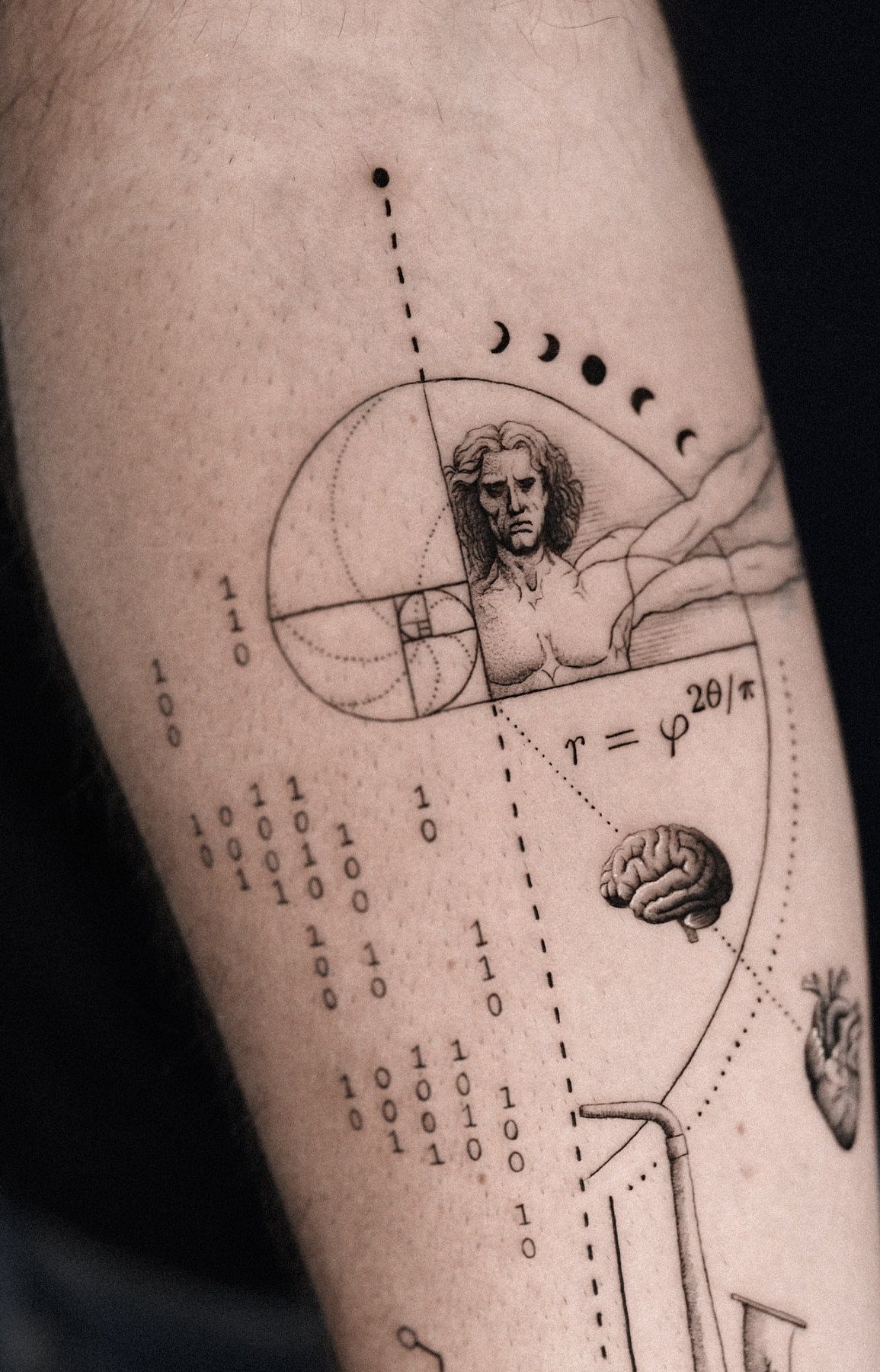 Fibonacci spiral tattoo with a portrait, brain, and heart on skin.