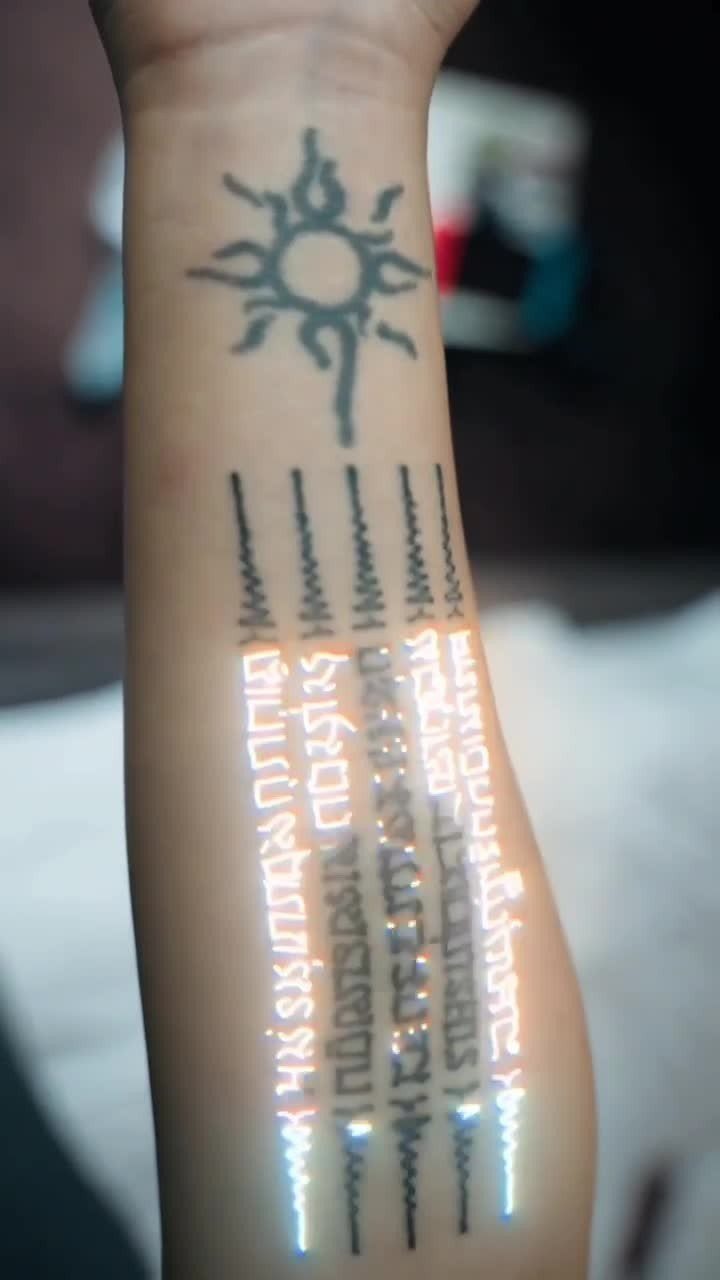 Forearm with a sun symbol and Hah Taew five lines Sak Yant tattoo