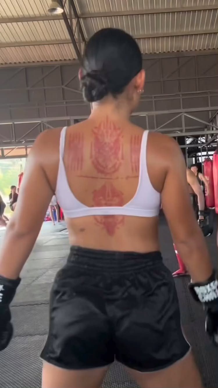 Woman boxer from behind showing a large Sak Yant tattoo on her back