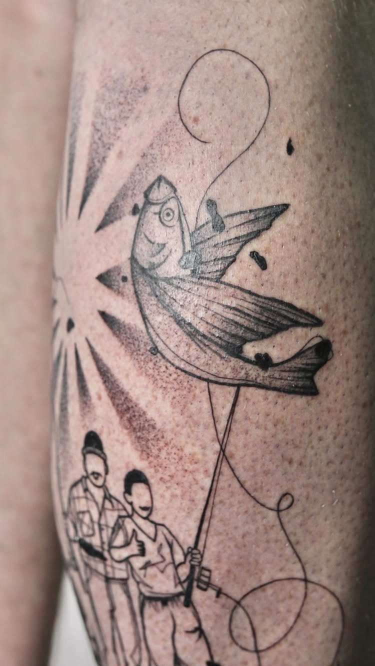 Tattoo of a man and boy fishing with a large leaping fish.