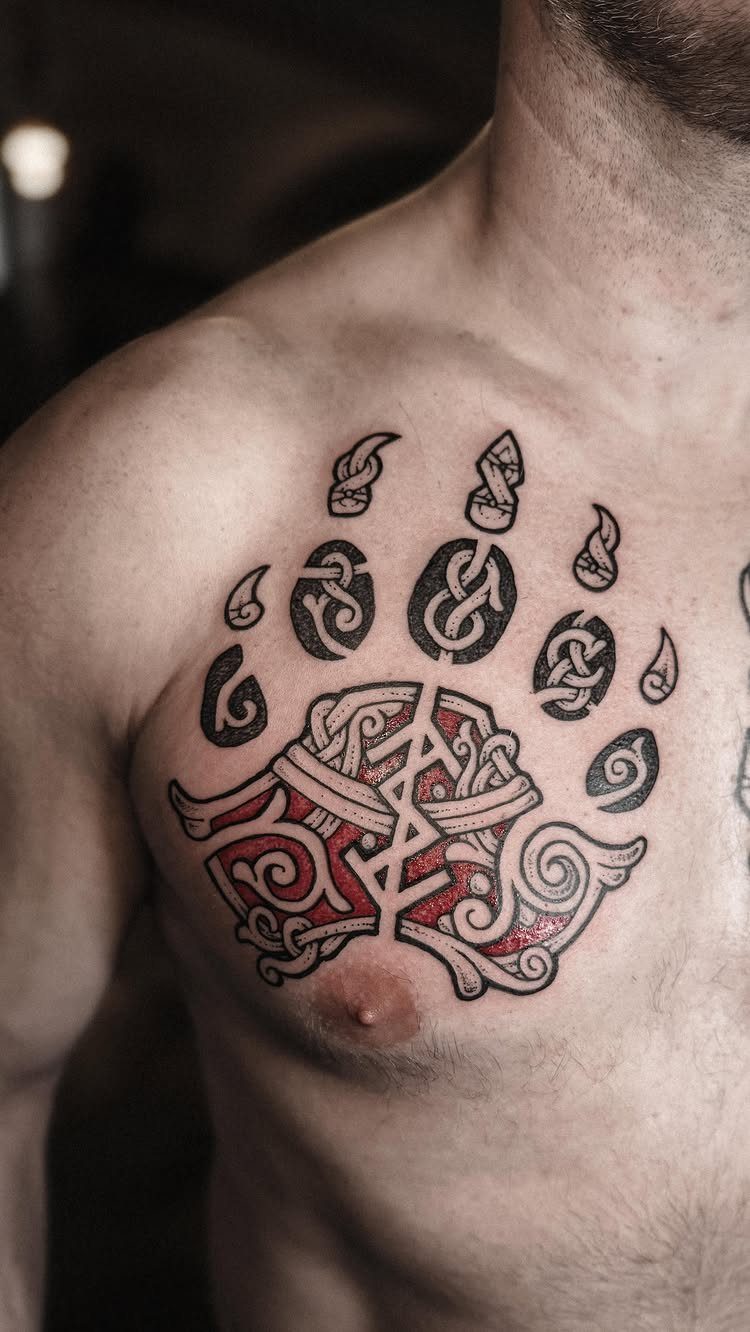 Bear paw tattoo with Celtic knots and a rune on a man's chest