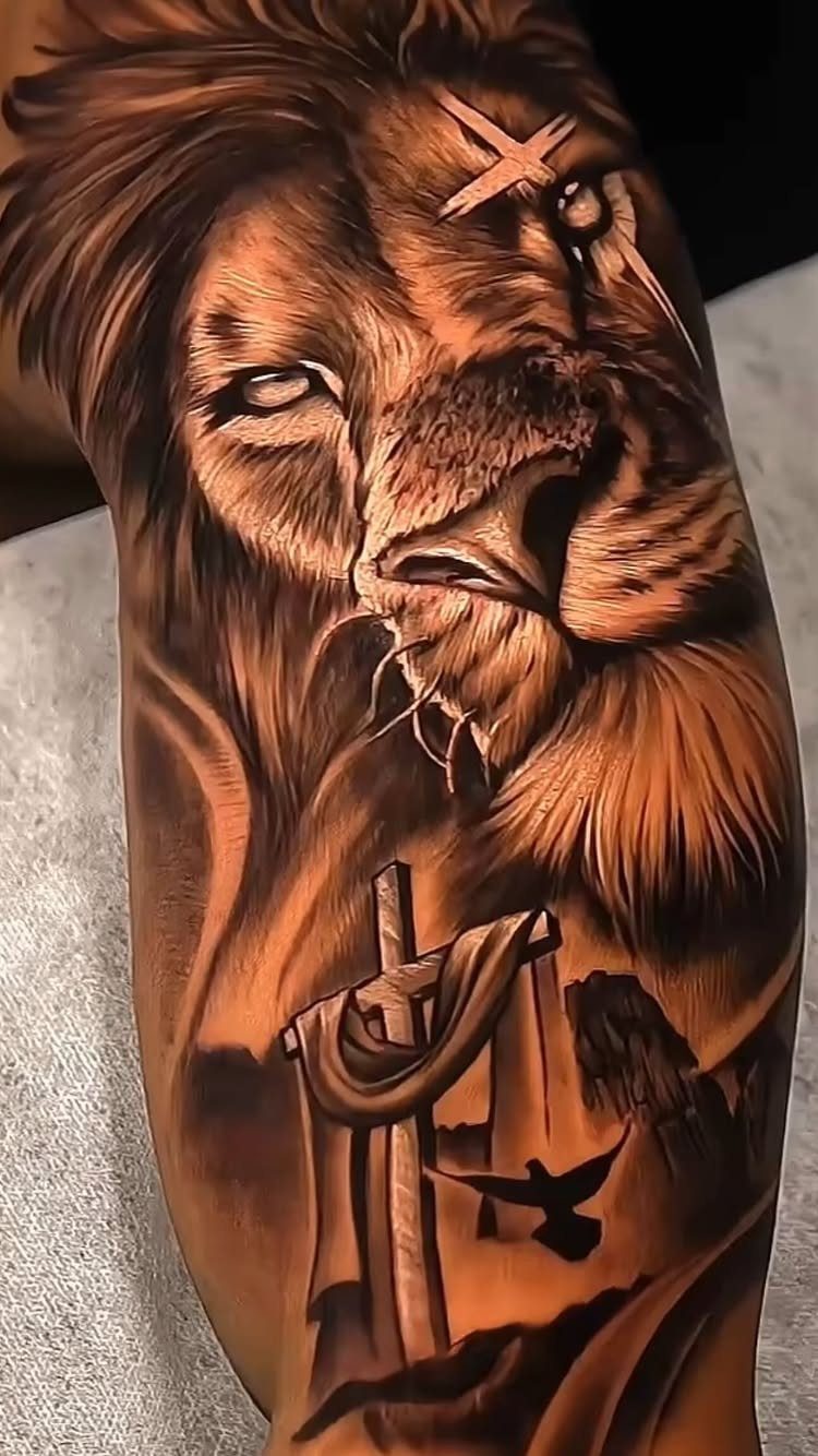 Lion of Judah tattoo with a cross and dove on a person's arm