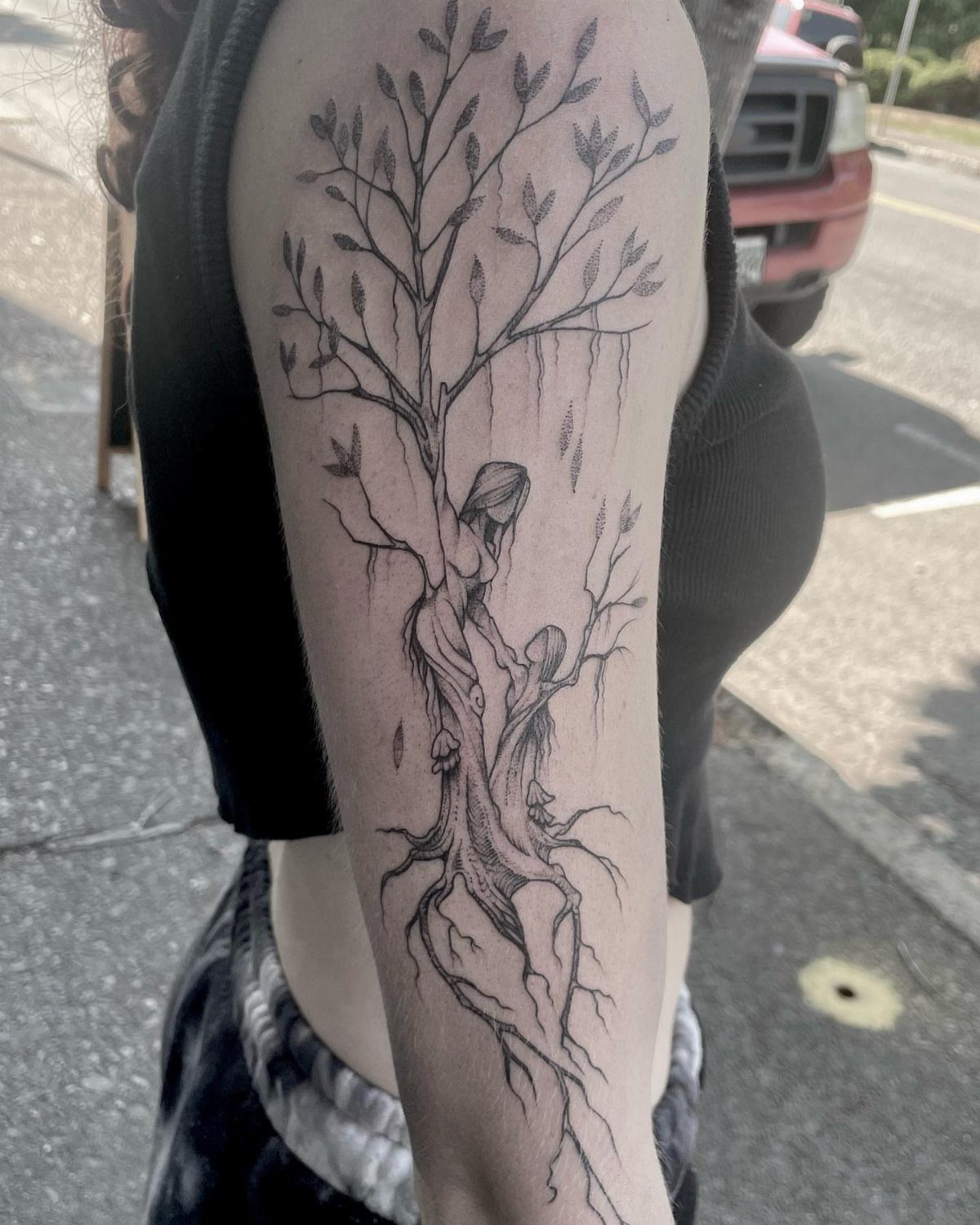 Tree tattoo on an arm with a mother and child silhouette in the trunk