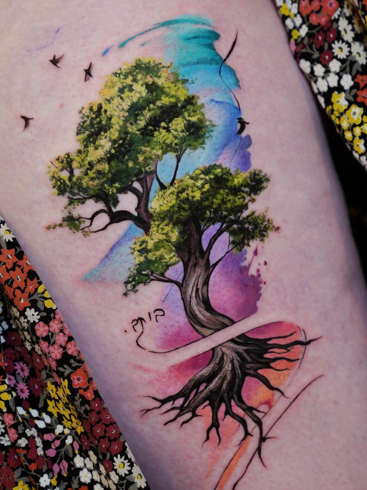 Colorful tree tattoo with green leaves and deep roots on human skin