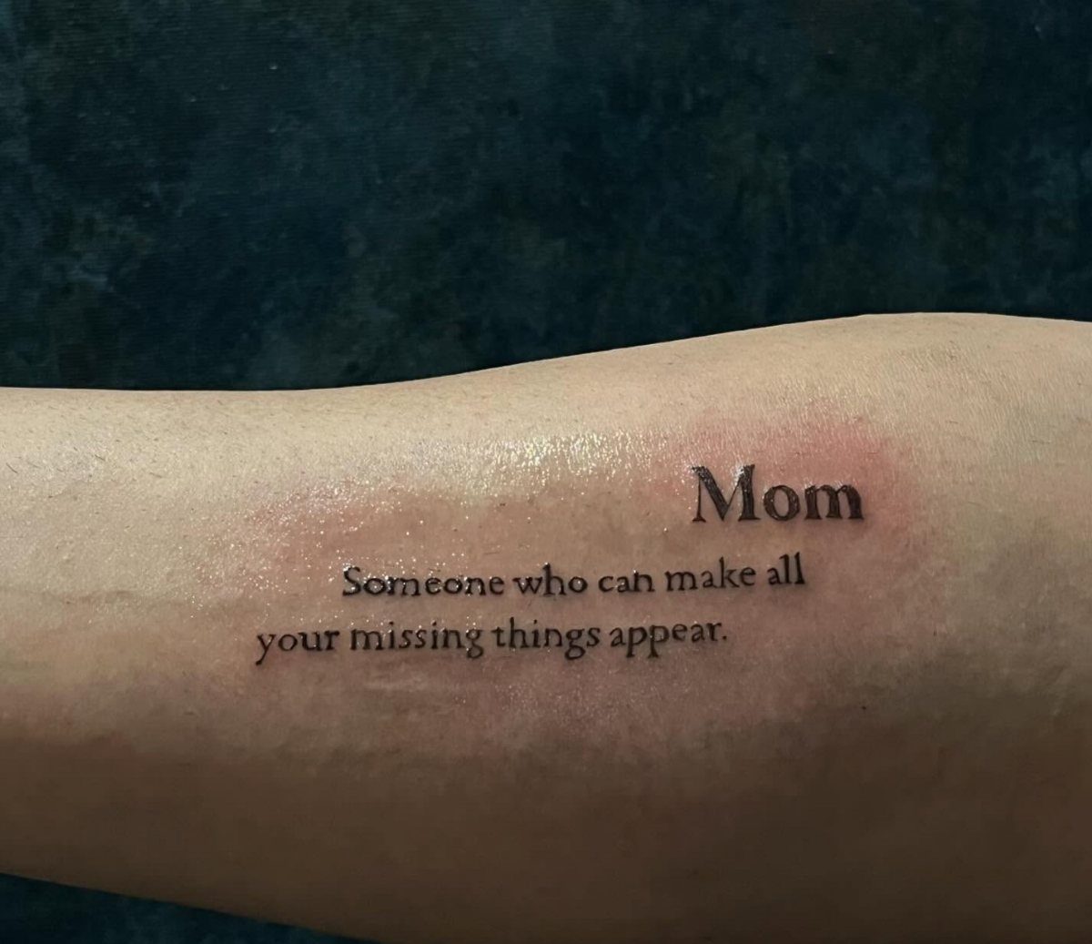 Tattoo on an arm with the quote Mom Someone who can make all things appear