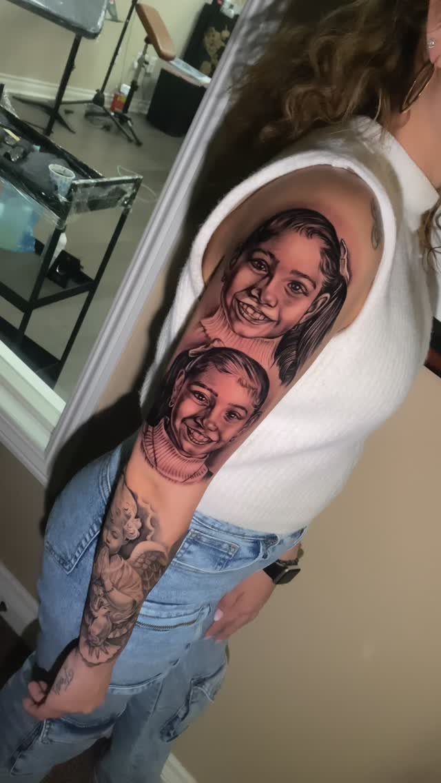 Realistic black and grey tattoo of two female portraits on a person's upper arm.
