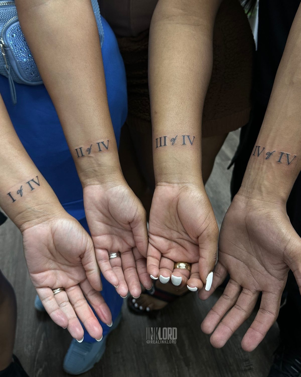 Four wrists with matching Roman numeral tattoos indicating their order in the family.