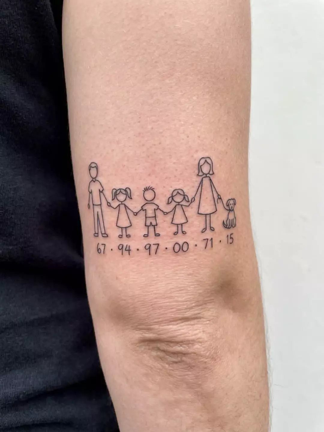 Stick figure family tattoo with birth years on a person's forearm