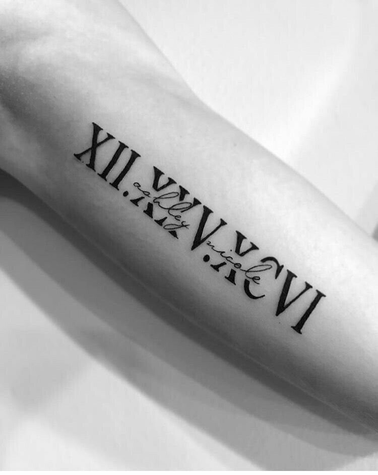 Roman numeral date tattoo with a cursive name on a person's forearm.